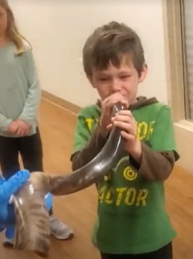 Kid playing shofar